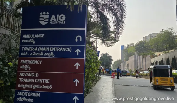 A modern, high-rise glass building with AIG signage at the entrance and a wide white driveway canopy, representing a key landmark near the Prestige Golden Grove residential project in Hyderabad.
