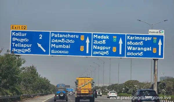 Highway directional sign on Hyderabad Outer Ring Road (ORR) showing Exit 02 for Kollur and Tellapur near the Prestige Golden Grove project