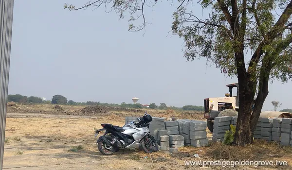 Panoramic view of the Prestige Golden Grove project site in Velimala, Hyderabad, showing initial ground leveling, boundary fencing, and early infrastructure development for the upcoming 10-tower luxury high-rise township.