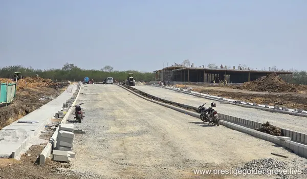 Construction progress at Prestige Golden Grove featuring a multi-story building frame and newly laid internal road infrastructure with kerbstone bordering