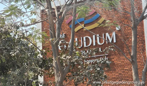 Exterior view of The Gaudium School signage on a red brick wall, showcasing the premium educational facilities located near the Prestige Golden Grove residential project.