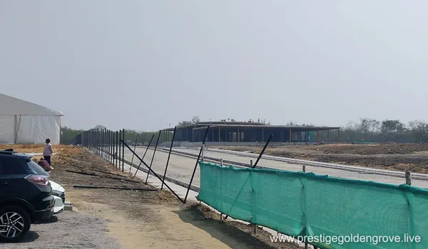Panoramic view of the vast 28.7-acre Prestige Golden Grove construction site in Velimala-Kollur, Hyderabad, showing initial land leveling and boundary fencing during the pre-launch phase.